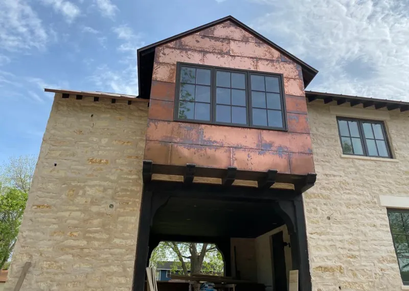 Copper metal panel facade on a stone building for Skylight Installation in Johnson Lane